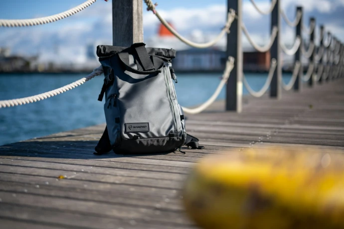 black and white leather shoulder bag on wooden dock